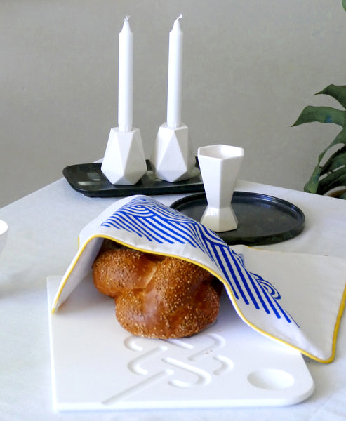 modern Shabbat table setting - corian Challah tray and geometric kiddush cup and candlesticks