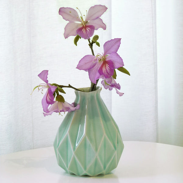 Light green ceramic vase in geometric origami style