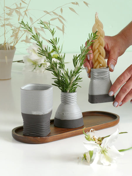 Modern 3d printed Havdalah set, innovative Judaica, Gray textured vessels with greenery as 'Besamim' on a wooden tray against a light green background