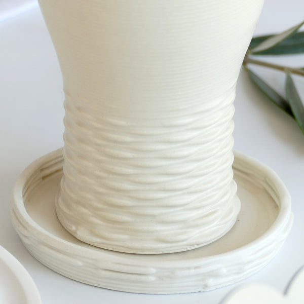 This elegant Kiddush cups set has clean shape with weaving pattern at its bottom - created in a unique method by a clay 3D Printer. The set includes one large Kiddish wine goblet with a plate, and six matching small cups.