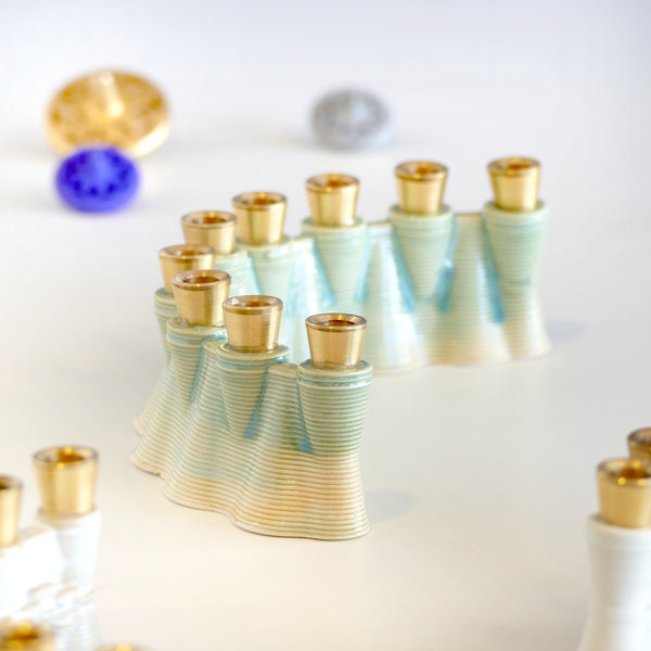 This contemporary Hanukkah Menorah features an arc shape with a delicate weaving pattern, created using a unique method with a clay 3D printer. Its gentle details and modest proportions make it look like a modern jewel. חנוכיה מקרמיקה בהדפסת תלת מימד, מכירת סאמפלים - שניים במחיר אחד