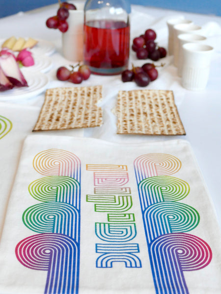 stylish and trendy set of a Matzah cover and Afikoman bag, crafted from fine off-white cotton. The design features an op-art-inspired wave pattern in stunning multicolor Ombre tones, printed using state-of-the-art 'Kornit Digital' textile printers. This design draws inspiration from the story of Exodus, merging tradition with contemporary aesthetic.