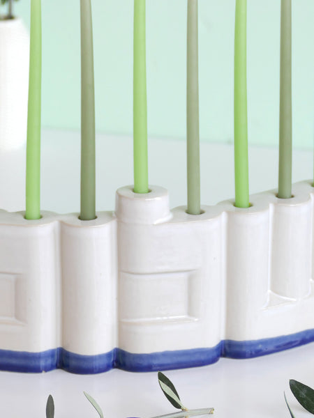 We designed the letters of "Shalom" in a minimalist, geometric style to form the Menorah's nine branches, with the central 'Lamed' (ל) serving as the Shamash.

Thanks to the completeness of the word שלום, it can be read clearly and elegantly from both sides of the Menorah – the convex and the concave. This dual-sided design makes it perfect as a table centerpiece or to place on a windowsill, projecting the message of peace both inwards and outwards.