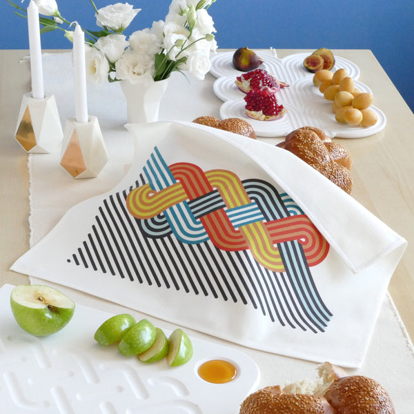 contemporary Rosh Hashanah table with modern Judaica, trendy Challah cover and more