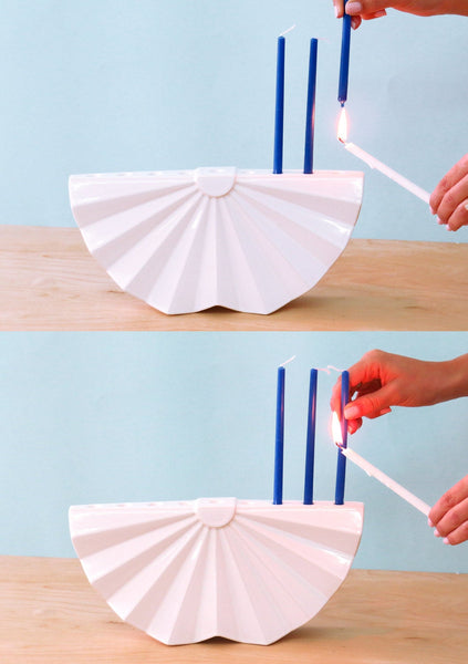 A modern ceramic Menorah, inspired by a simple Origami fold, a round 'zig - zag' that creates a fan shapes. 